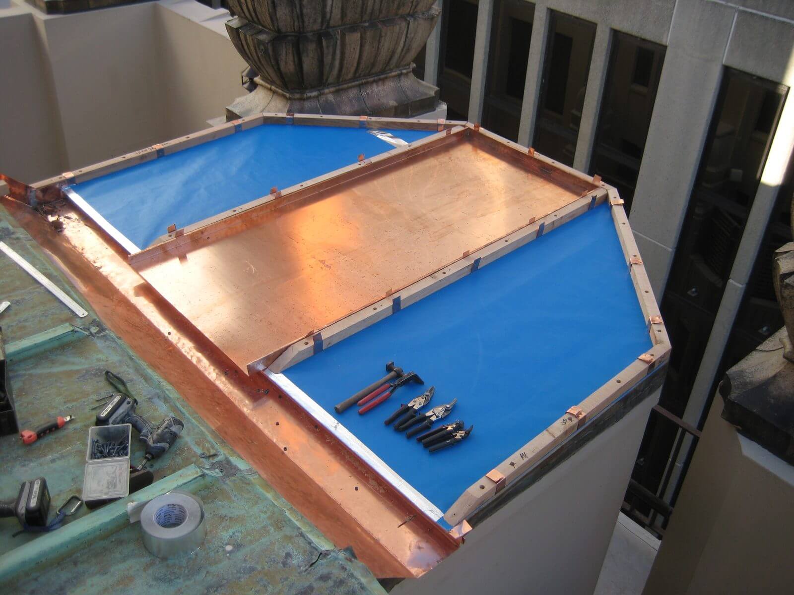 Copper roof in progress with underlay, timber edges and roofing tools