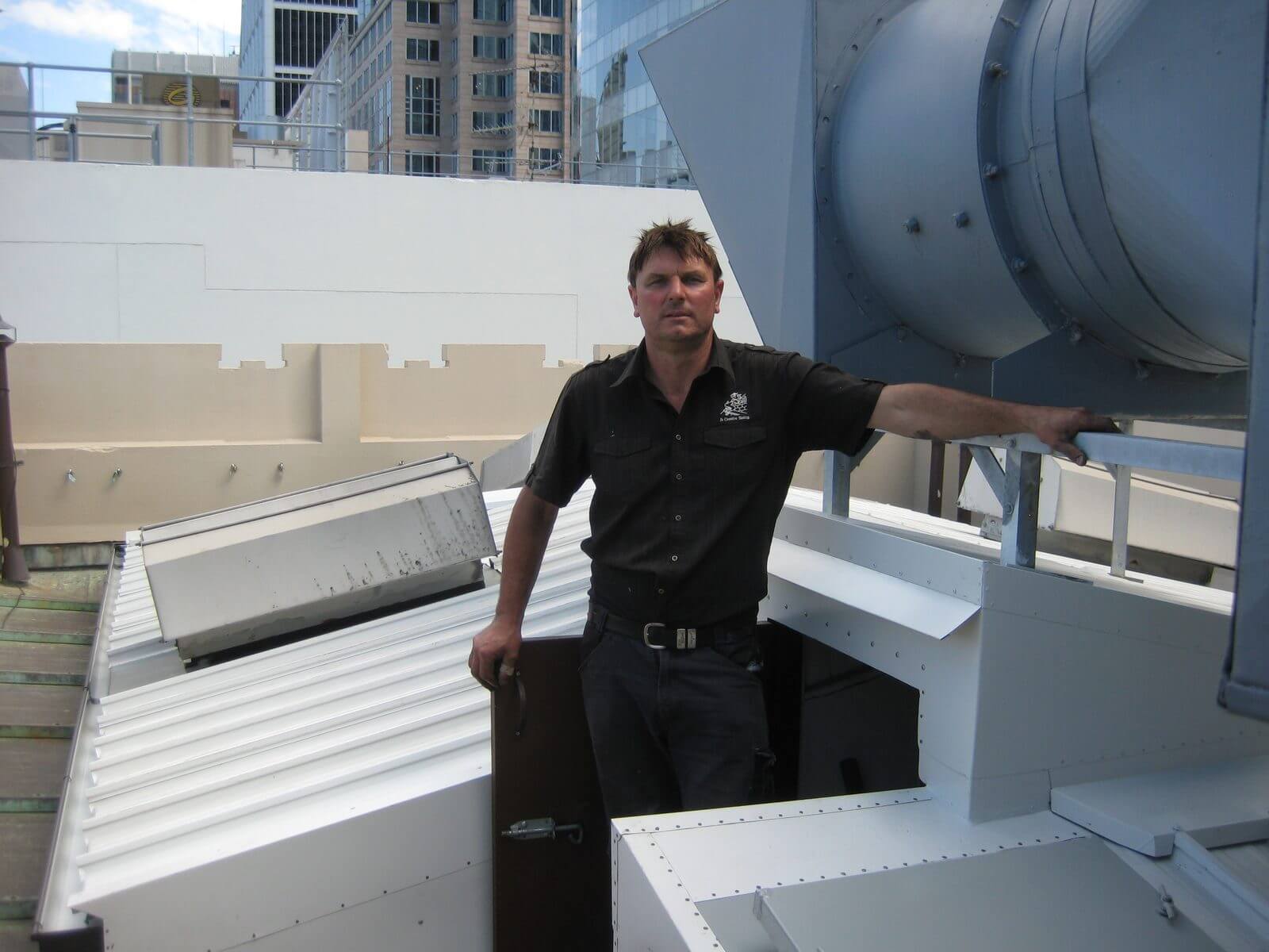 Jeremy Williams standing beside a finished custom metal roof