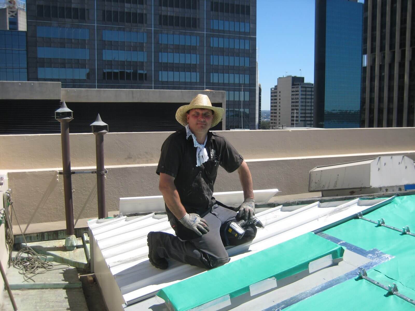 Jeremy Williams kneeling on a custom metal roof during installation